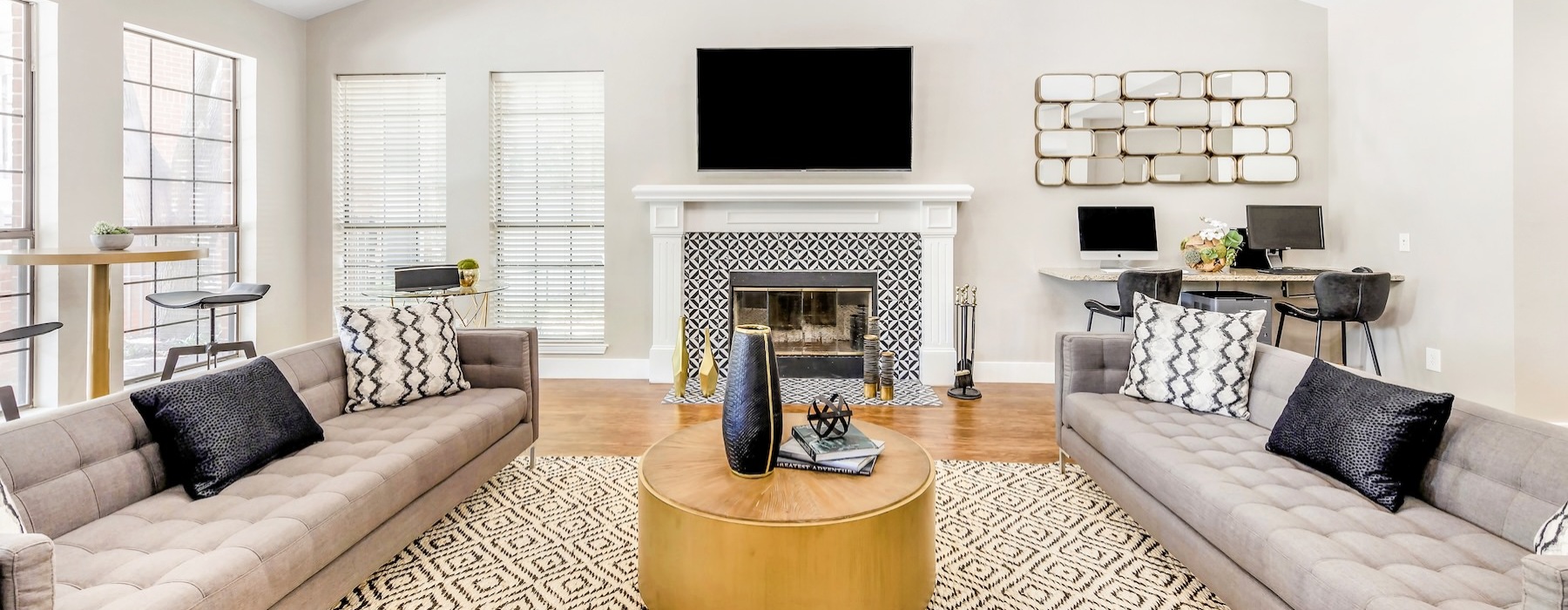 a clubroom with a fireplace, couches and a tv